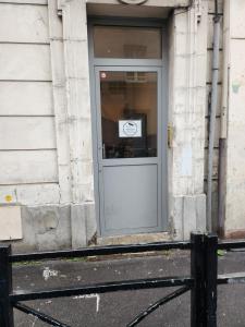 a door of a building with a sign on it at Studio proche Paris in Saint-Denis +2 photos