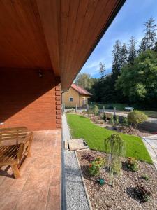 a patio with a bench and a garden at Roubenka Na Číně in Želiv