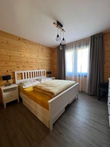 a bedroom with a large bed with a wooden wall at Roubenka Na Číně in Želiv