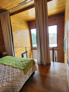 a bedroom with a bed and two windows at Casa Cortés Golf - Boutique in Sierra de la Ventana