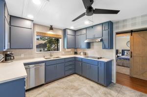eine Küche mit blauen Schränken und einer Spüle in der Unterkunft Das Bach Haus - Game Room Make-Up Room & Hot Tub in Fredericksburg + 39 Fotos