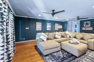 ein Wohnzimmer mit einem großen Sofa und einer blauen Wand in der Unterkunft Das Bach Haus - Game Room Make-Up Room & Hot Tub in Fredericksburg