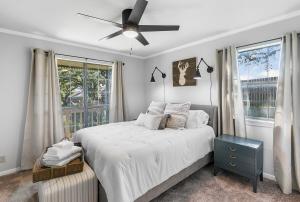 ein Schlafzimmer mit einem Bett und einem Deckenventilator in der Unterkunft Das Bach Haus - Game Room Make-Up Room & Hot Tub in Fredericksburg