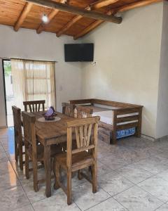 Un comedor con mesa y sillas de madera. en Cabañas D Noris, en Los Hornillos
