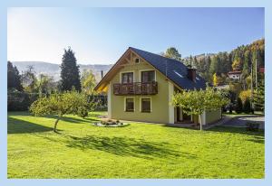 una casa gialla con balcone su un prato verde di Domek na Leśnej Wisła a Wisła