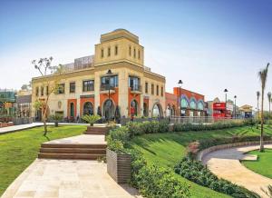 a large building with a park in front of it at Luxury Heaven 10 in Madinaty