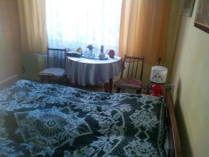 a bedroom with a bed and a table in a window at Hotel Premiér Poprad 13 Jeseň vo Vysokých Tatrách in Poprad