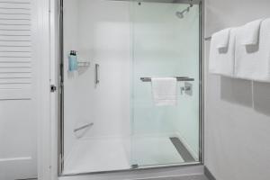 沃灵福德Courtyard by Marriott New Haven Wallingford的浴室设有玻璃淋浴间,配有白色毛巾