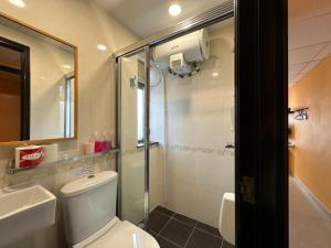 a bathroom with a shower and a toilet and a sink at Bali Holiday Resort in Hong Kong