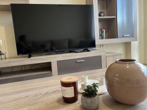 a living room with a television and a vase on a table at Cozy apartment - free parking in Plovdiv