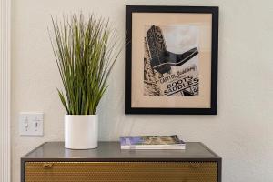 un cuadro en una pared con una planta en una mesa en Haus on the Hill - Hot Tub & 1 Mile From Main St, en Fredericksburg