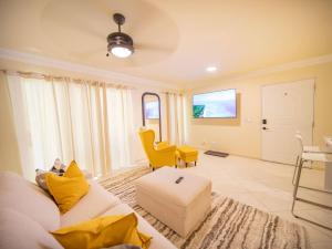 ソスアにあるGarden Condos 21, Modern 1BR APT In Sosua Strip GUEST FRIENDLYのリビングルーム(白いソファ、黄色い椅子付) +10枚の写真