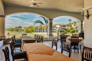 a restaurant with tables and chairs and a large window at Taheima 2104B at El Tigre in Nuevo Vallarta 