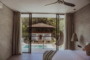 a bedroom with a bed and a view of a pool at The Salty Pelican Yoga & Surf Retreat in Dickwella +41 photos