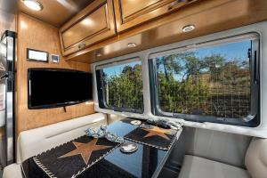 a room with two tables and two windows in an rv at Airstream Getaway - Hot Tub & Fire Pit in Luckenbach
