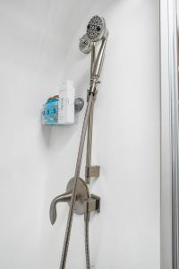 a shower head hanging on a white wall at Airstream Getaway - Hot Tub & Fire Pit in Luckenbach +30 photos