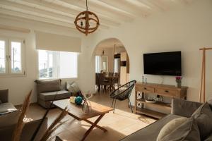 a living room with a couch and a flat screen tv at Paradisia Villas in Tourlos