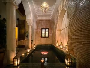 a room with a hot tub with candles in it at Riad Alena in Marrakesh