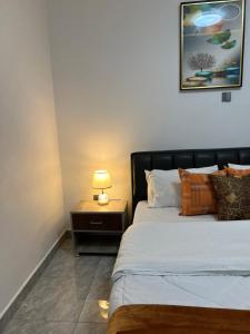 a bedroom with a bed and a lamp on a night stand at CosyNook B in Kigali