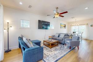 a living room with two blue chairs and a ceiling fan at Salt & Sand Sanctuary in Orange Beach