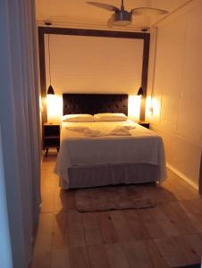 a bedroom with a bed with two lights on it at Condomínio Villa de Portugal Suíte Por do Sol in São Francisco do Sul +16 photos
