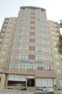 un gran edificio con un cartel en la parte delantera en Continental Inn Hotel Al Farwaniya en Kuwait