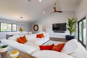 ein Wohnzimmer mit weißen Sofas und einem Flachbild-TV in der Unterkunft Tropical Treasure Retreat in Marco Island
