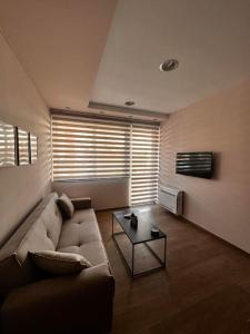 Una sala de estar con un sofá y una mesa de café. en The rabbits' house, en Nauplia