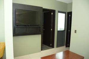a living room with a flat screen tv and a window at Comfort House La Herradura in Arandas