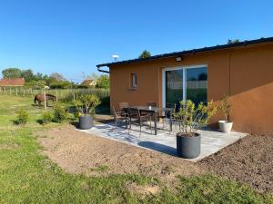 a house with a table and chairs in a yard at Un séjour à la ferme in Sommery