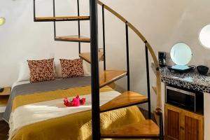 a room with a bed and a spiral staircase at Villa Heliconia in Barra de Navidad