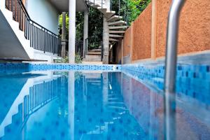 a swimming pool with blue tiles and stairs at Vana by Loka - Nature Inspired Studios in Auroville