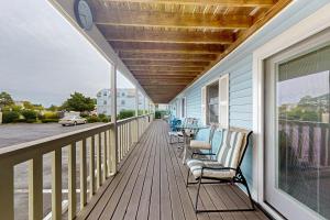 a balcony with chairs and a table and a clock at Marathon North 103 in Ocean City