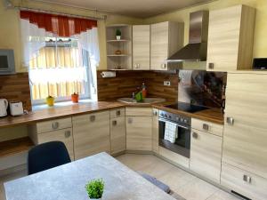 a kitchen with wooden cabinets and a table and a window at Ferienwohnung Bangert in Idar-Oberstein