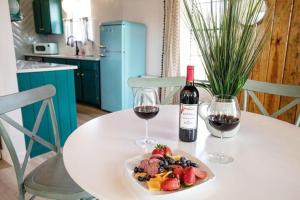 einen Tisch mit einem Obstteller und zwei Gläsern Wein in der Unterkunft Sunday Circle - Hot Tub & Hill Country Wine Trail in Fredericksburg