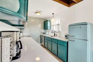 eine Küche mit grünen Schränken und einem blauen Kühlschrank in der Unterkunft Sunday Circle - Hot Tub & Hill Country Wine Trail in Fredericksburg