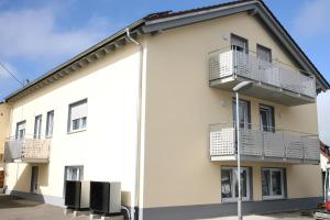 a white building with balconies and a street light at Ferienwohnung Schnell Herbertingen in Herbertingen