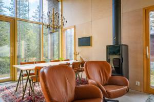 Un comedor con mesa y sillas y chimenea. en Villa Kuuru Hillside, en Ruka