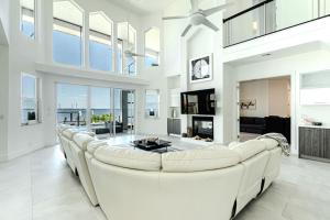 - un grand salon blanc avec un grand canapé blanc dans l'établissement Breathtaking 6BD Riverfront Mansion w Pool, à Cape Coral