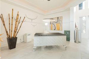 a living room with a piano in a white room at Breathtaking 6BD Riverfront Mansion w Pool in Cape Coral