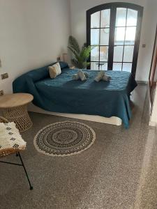 Un dormitorio con una cama grande con una manta azul. en Aquamarina House, en Caleta de Fuste
