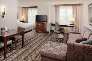 Una habitación de hotel con una cama, un sofá y un escritorio. en Residence Inn Worcester, en Worcester