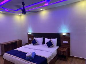 a bedroom with a bed with purple lights on it at Golden hills cottage in Viripara