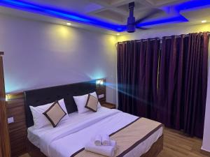 a bedroom with a bed with blue lights on it at Golden hills cottage in Viripara +23 photos