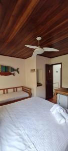 a bedroom with a white bed and a wooden ceiling at Pousada Manga Rosa in Paraty