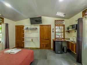 a bedroom with a bed and a kitchen with a sink at Ú Sulè in Cahuita