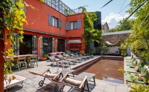 Un patio al aire libre con sillas y una piscina. en Communal Hotel Telavi, en Telavi