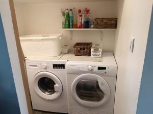 a laundry room with a washer and dryer at Gîte la Korrigane 4 personnes classé 3 étoiles in Pouldreuzic