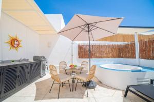 a patio with a table and chairs and a bathtub at papaya 15 Exclusive PentHouse with rooftop and jacuzzi in Playa del Carmen
