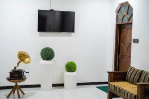 a living room with a couch and a tv on a wall at Heaven Habarana in Habarana